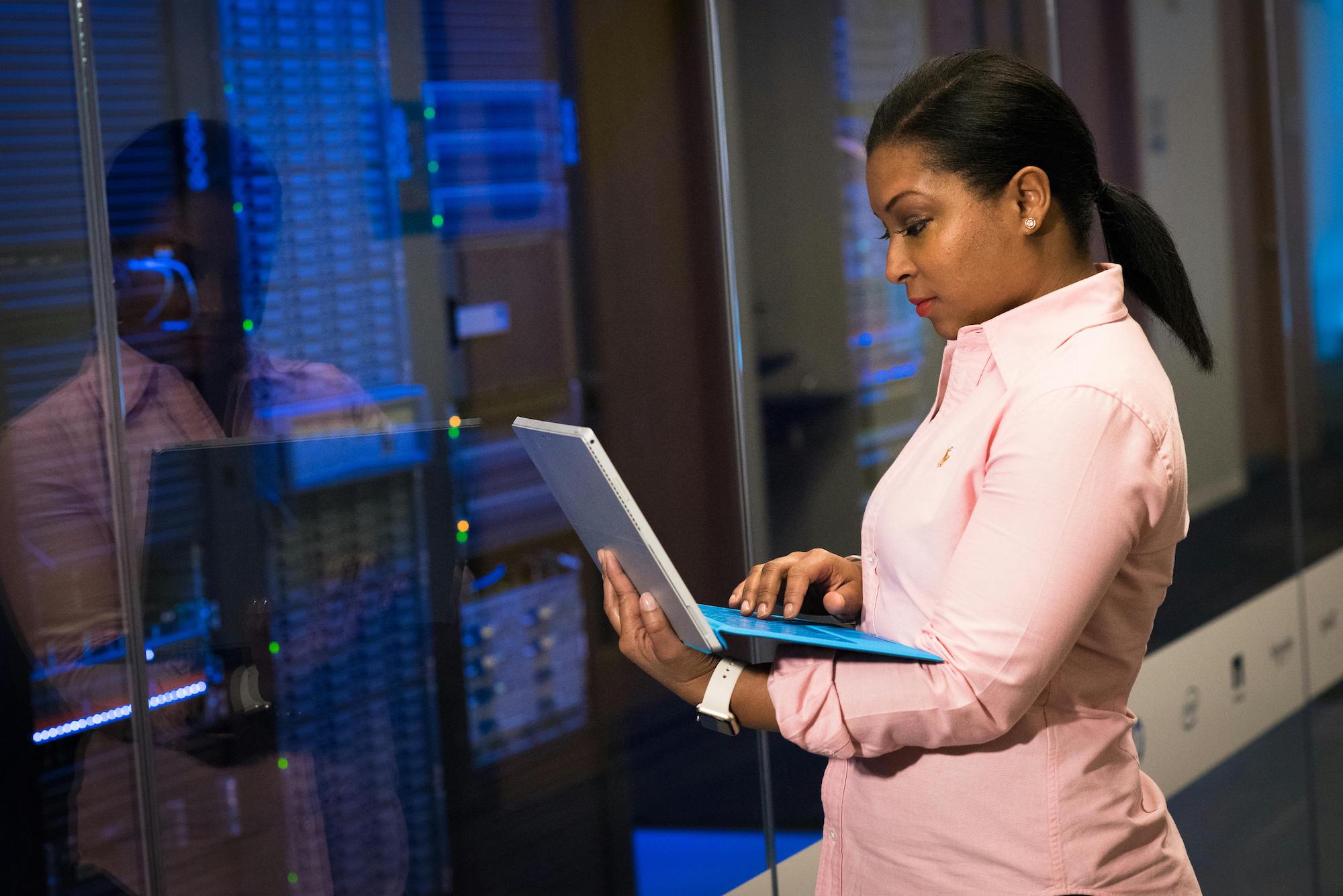 woman assesses servers while holding laptop